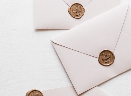 White envelopes with gold seals on them