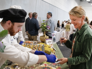 Caterer handing food to person at the annual FVCC festival of flavors