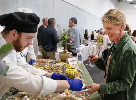 Caterer handing food to person at the annual FVCC festival of flavors