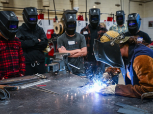 Flathead Valley Community College instructor Julie Arnold shows a group of prospective students different welding techniques during the college's Night of the Trades open house on Thursday, Oct. 3. (Casey Kreider/Daily Inter Lake)